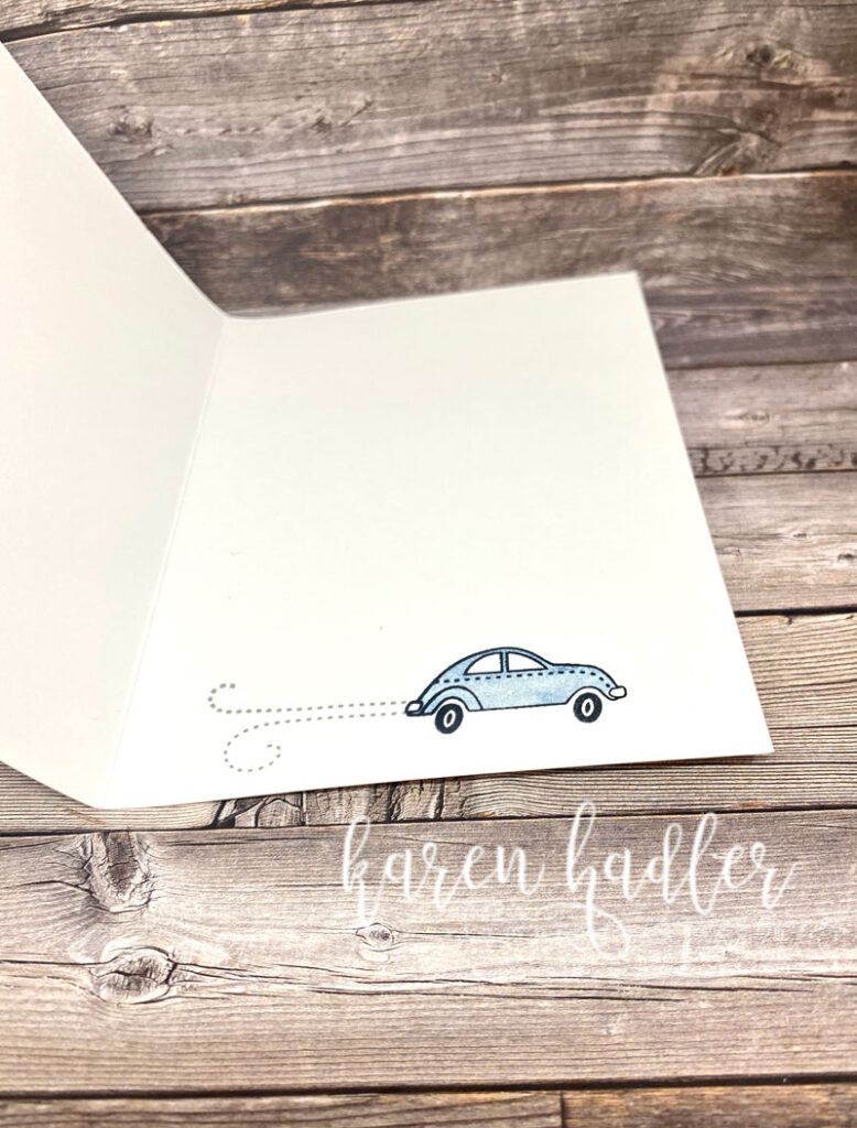 Inside of the baby card which has a Blue car driving across the bottom of the card with exhaust fumes. 