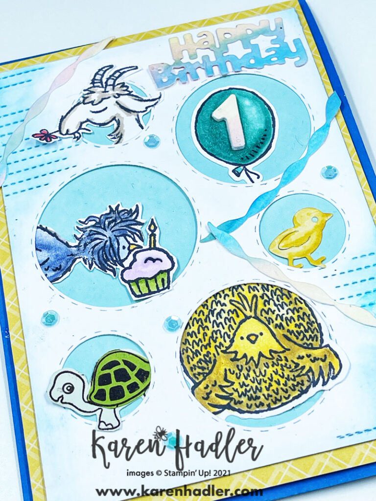 A close upPicture this Fun Animal 1st Birthday Card. The card is on a bright blue base with a yellow mat. On top is a white mat with different size holes. In these holes are different animals a turtle, chickens, chicks, a goat. There are also streamers and the words Happy Birthday have been die cut out. It is a bright happy Card.