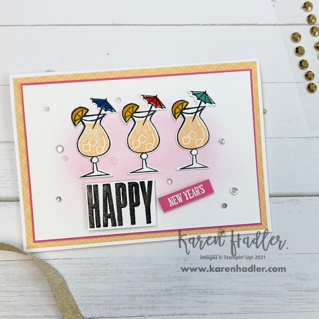 A picture with a card and Text. The words say Happy New Years. The back ground is a soft Pink and there are three cocktail glasses across the middle. Complete with lemons and umbrellas.