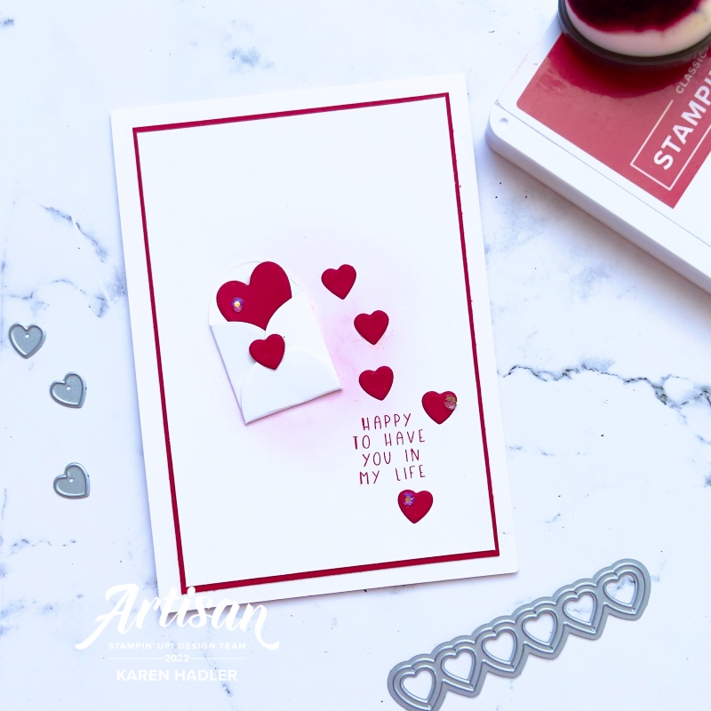 A picture of a red and white card with text. The words are Happy to Have you in my life. There is a small white envelope in the centre with red hearts coming out and down the card.
