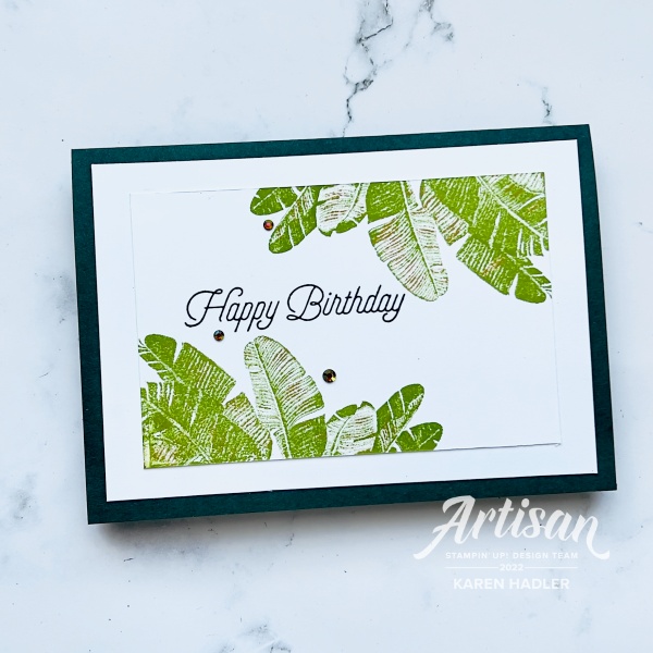 A picture of a Card with Text. There are luscious Broad green leaves farming the top and the Bottom with the words Happy Birthday written across the middle.  