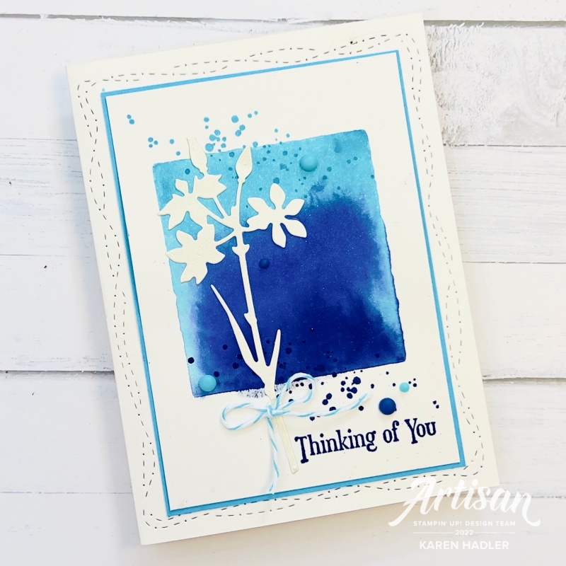 A greeting card Thinking of You with blue hues in a water colour block in the middle of the card.
