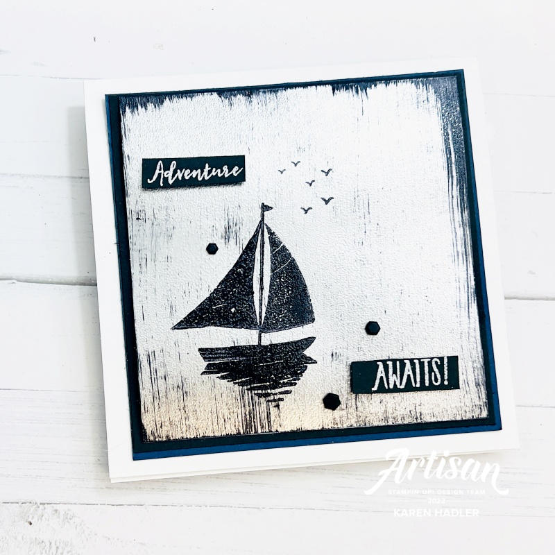 A Silver foil shimmery card with sail boat and says Adventure awaits.