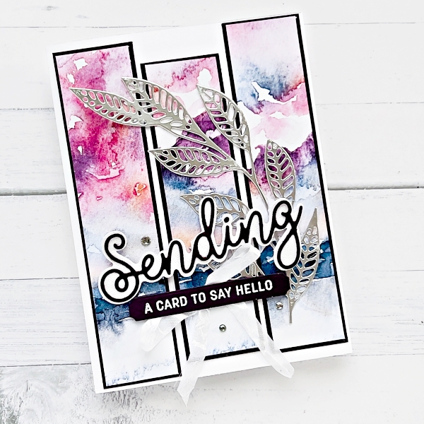A picture of a greeting card with 3 water colour strips and a large silver leaf running across the from. The sentiment reads Sensing a card to say hello.
