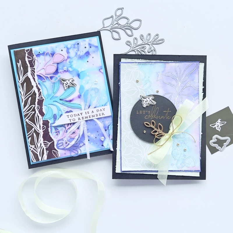 A picture of two cards with Two Ways to add Gorgeous Backgrounds One Water colour resist and one Isopropyl Alcohol Celebrating a Splendid day . One background is bright and the other more subdued in purples and pinks.