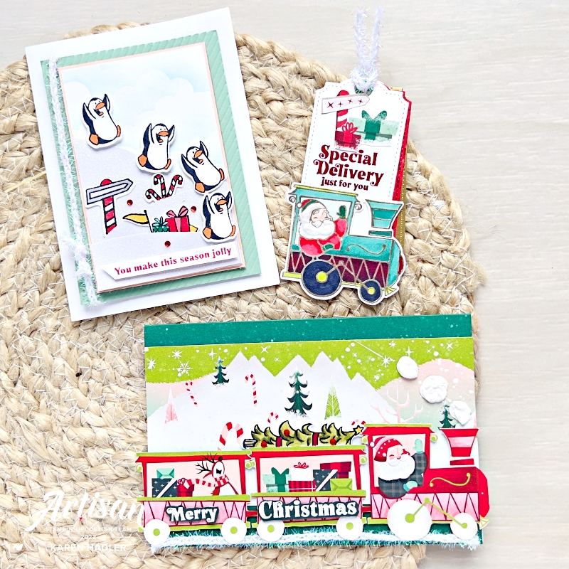 A picture of 2 Christmas Greeting cards and a Christmas Tag. One card has a red train along the bottom with Santa driving. There are presents in the train and the sentiment reads Merry Christmas.
There is also  a Christmas card with Penguins sliding down glimmer white hills . The sentiment reads you make this season jolly.
The Christmas tag that reads Special delivery just for you. There is a Santa in the front carriage of a train waving.