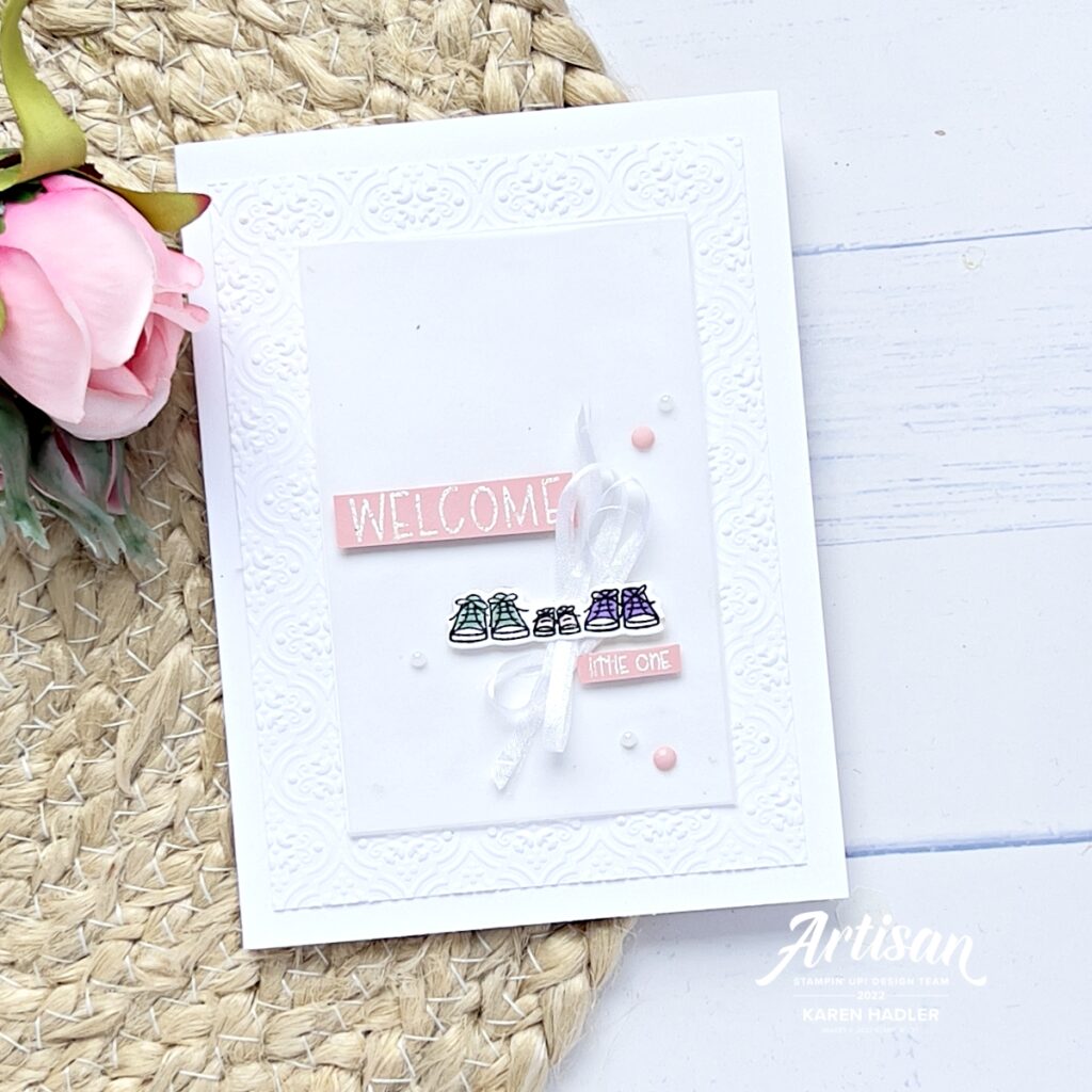 A picture of a Basic White Greeting Card with 3 pairs of shoes, Mum, dad and Baby. The sentiment reads Welcome little one.