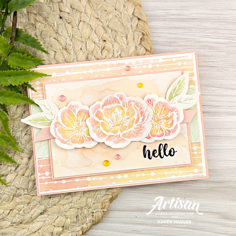 A picture of a greeting card that has 3 water colour Blooms on the front and a water coloured Background in Petal Pink. The sentiment reads Hello