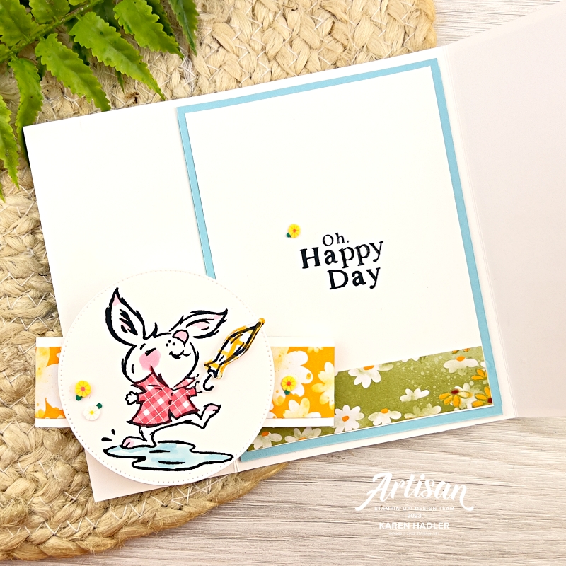 A picture of the inside of a gatefold card that says Oh Happy Day. To the left is a belly band with a circle. In the circle is a white rabbit playing in a puddle with an umbrella.