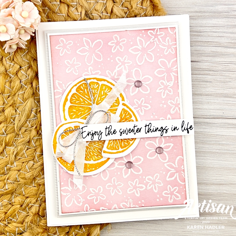 A white based greeting card with a pink mat with lots of small white flowers all over it. To the left is a group of shiny lemons and the sentiment reads Enjoy the sweeter things in life.