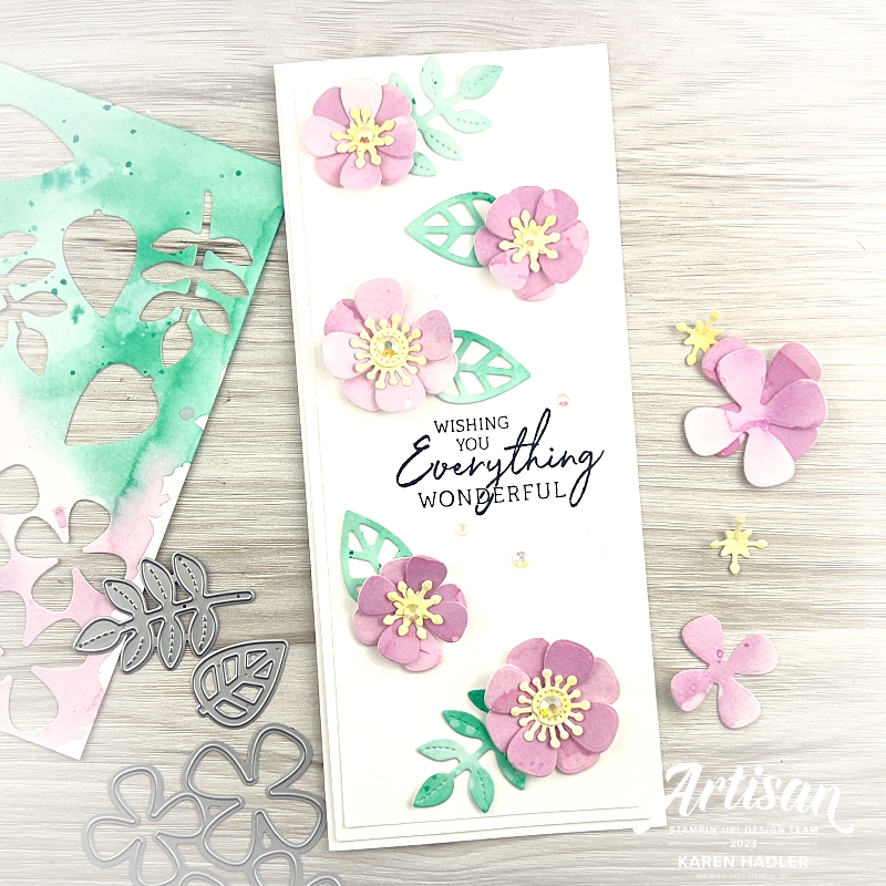 Image: of a slim line White card with 5 Fresh Freesia Water coloured Flowers and Coastal Cabana Leaves scattered over the card. The sentiment reads Wishing you everything wonderful. In the background is the water coloured paper and the dies showing how the flowers were created. 