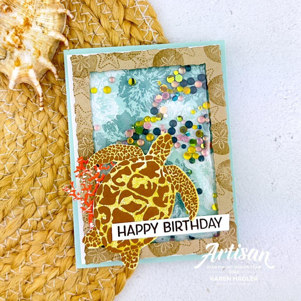 A picture of a shaker card. It has a pool party base and a stamped with star fish and sand dollar Crumb cake frame . The back ground is splashes of pool Party and Lost lagoon. There is inside some loose frosted coloured dots that make the shaker. On the outside is a large turtle and the sentiment reads Happy Birthday.