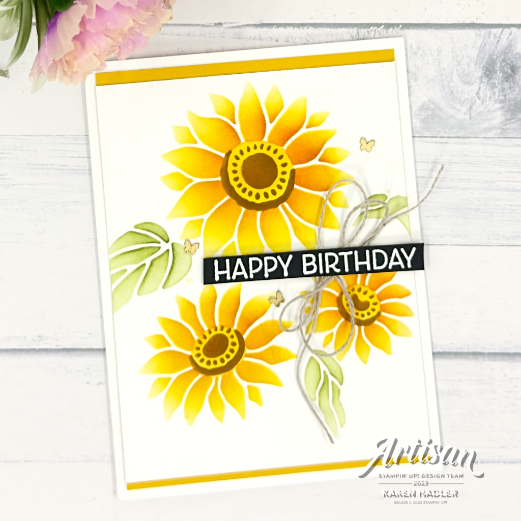 A greeting card on a white card base with a Crushed Curry mat The front has another white mat with 3 gorgeous yellow flowers with yellow and brown centres. There are 3 green leaves and the sentiment Happy Birthday is White embossed on black cardstock. This is across the flowers with a linen thread bow underneath. The are also 3 brass butterflies on the card.