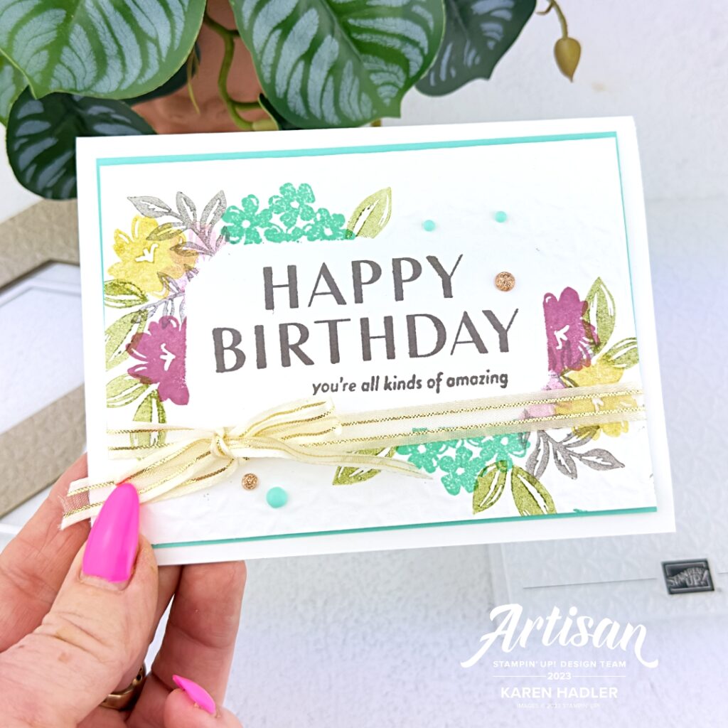 A greeting card with a large Happy Birthday in the middle and in smaller lettering beneath words that read you're all kinds of amazing. This is onl flat card stock and the area around is embossed and stamped with flowers and leaves