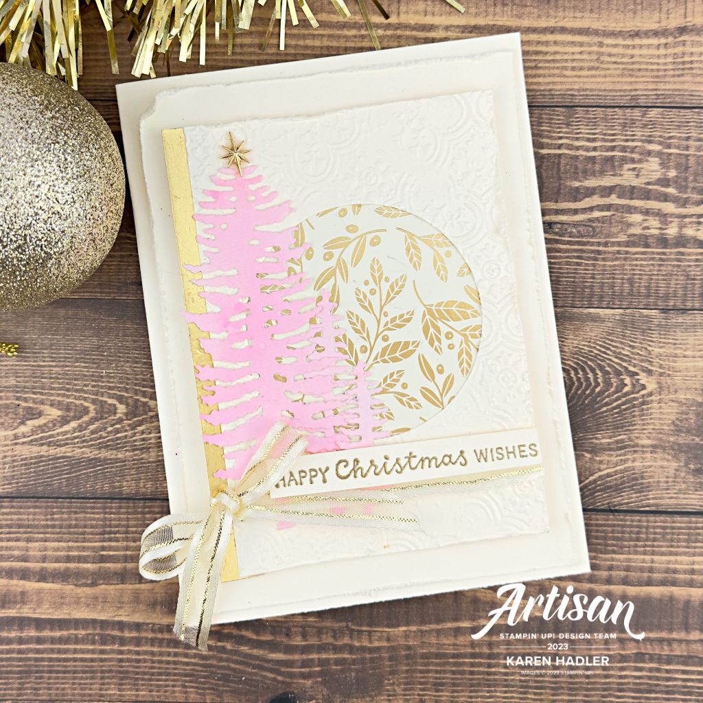 A Christmas Greeting Card with a Very Vanilla Base , pink trees and gold highlights. The is a circle in the niddle with some gold and cream paper. T the left is the pink trees. Running across the  bottom is a gold shimmery ribbon and a bow to the left. The words Happy Christmas wishes are Gold embossed. and there is a gold star at the top of the talles tree.