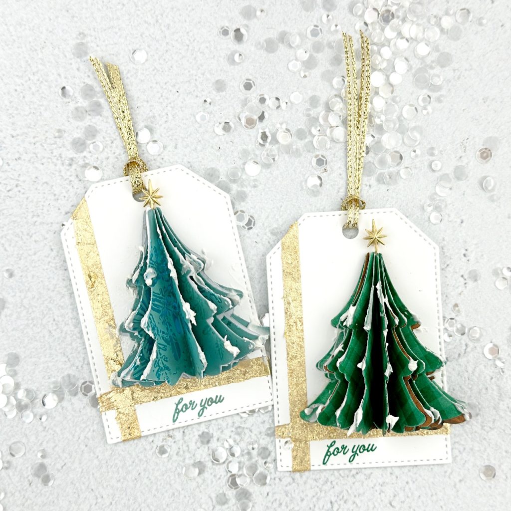 Two gorgeous Christmas Tags on a White Tag base. There is a gold strip of gilded leafing running down the left  hand side and across the bottom of the tag. in the middle is a 3D tree that has 8 die cut trees from Green Designer Series paper,  folded in half and glued together. The sentiment at the bottom reads For You and is also stamped in Green. There is a Gold Star at the top of the tree and gold shimmery twine at the top to tie.