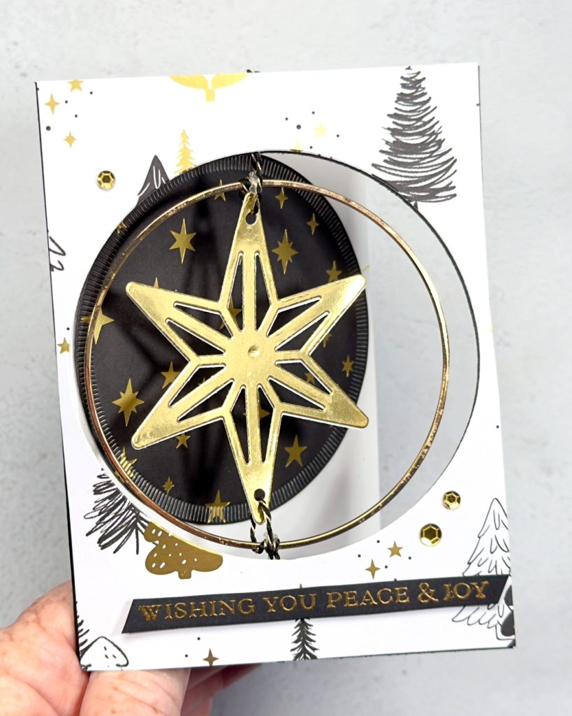 A black, white & gold Christmas card with a circle in the middle with a gold star that spins. The sentiment reads Wishing you Peace & Joy