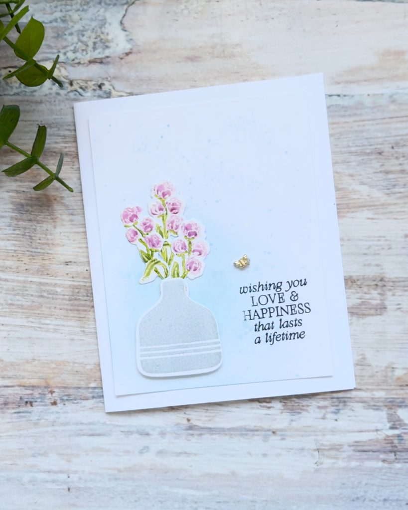 Clean and simple handmade card with stamped pink flowers in a vase, soft blue ink blending and “wishing you love and happiness” sentiment.