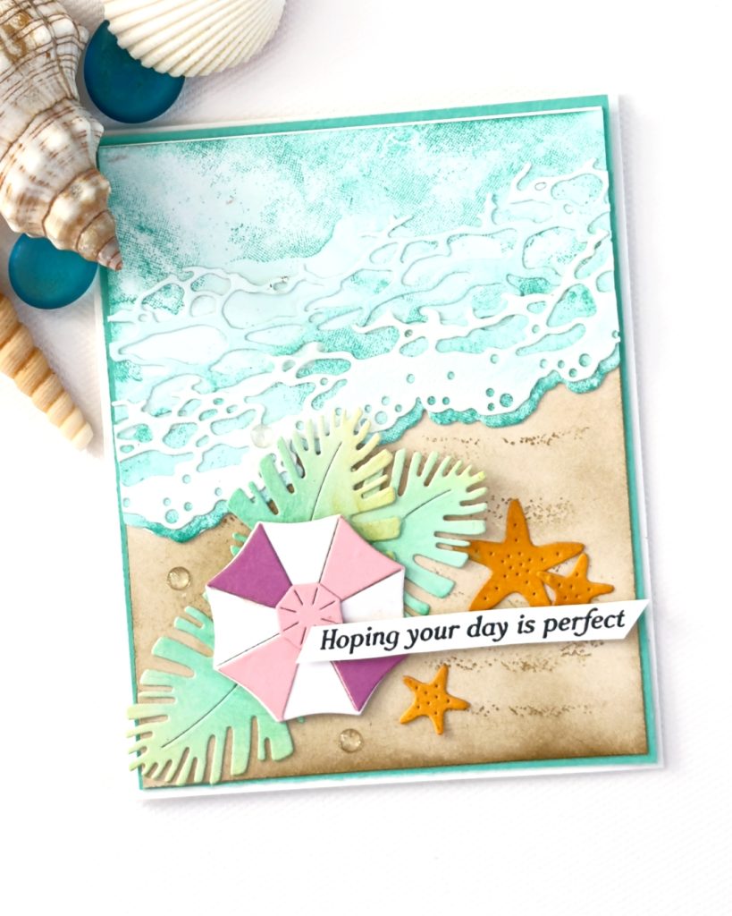 Beach-themed handmade card using Stampin’ Up! Rolling Waves Bundle, featuring ink blending techniques, textured ocean waves, sandy background, tropical leaves, and umbrella focal point.