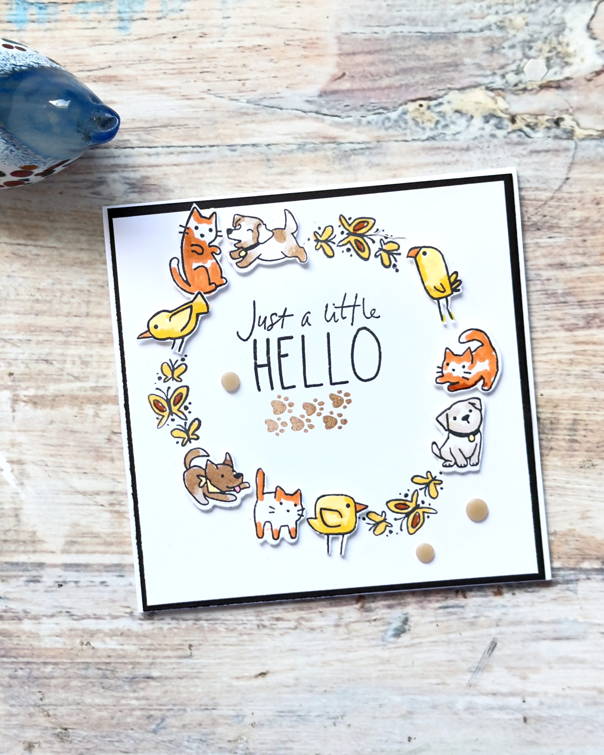 Handmade square card featuring a wreath of stamped cats, dogs and birds using the Stampin’ Up! Cutest Crew Bundle with the sentiment “Just a Little Hello”.