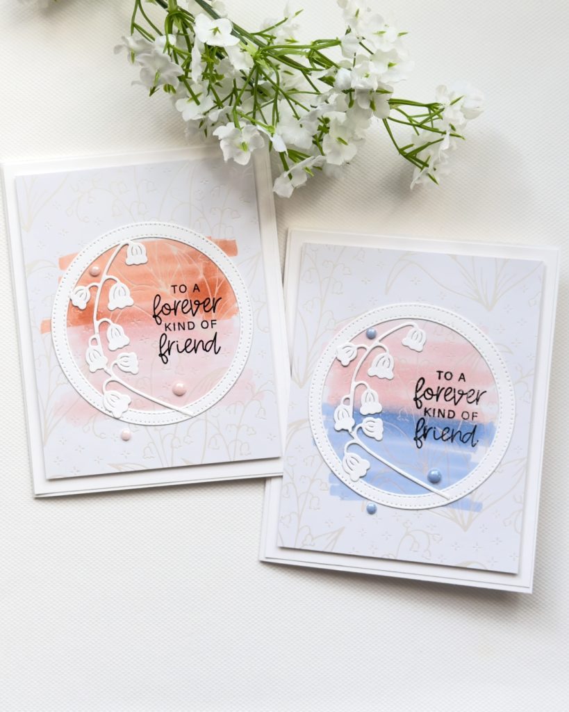 Two handmade friendship cards with lily of the valley die cuts, soft blended pastel circle backgrounds, and “forever friend” sentiment on a subtle patterned base.