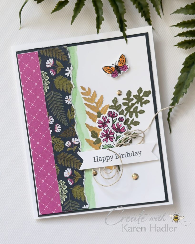 Handmade birthday card featuring torn botanical designer paper, layered die cut foliage, pink floral stamping, butterfly embellishment and a “Happy Birthday” sentiment on a white background.