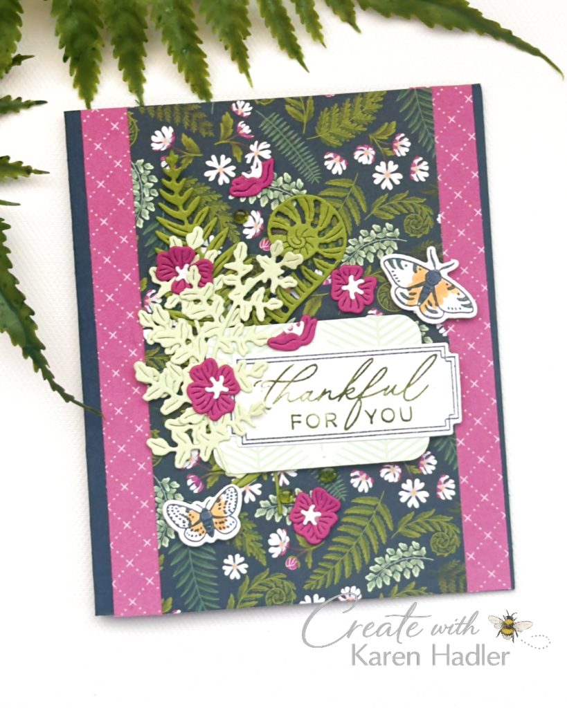 Handmade botanical thank you card featuring fern patterned designer paper, layered die cut foliage and flowers in Berry Burst and green tones, moth embellishments and a “Thankful For You” sentiment on a navy background.